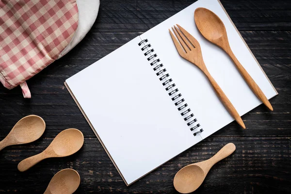 木制表面和木制勺子和叉子上的文本笔记空白笔记本 — 图库照片