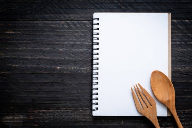 metin Not ahşap yüzey ve tahta kaşık ve çatal ile kopya sapce için boş defter