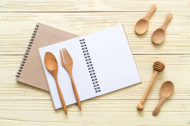 metin Not ahşap yüzey ve tahta kaşık ve çatal ile kopya sapce için boş defter