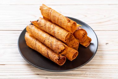 Çıtır çıtır kurutulmuş kalamar ruloları tabakta.