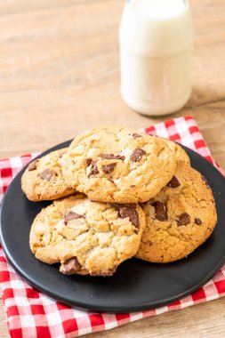 Tabağında çikolata parçaları olan kurabiyeler.