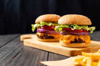 taze lezzetli biftek burger peynir ve patates kızartması ahşap arka plan üzerinde