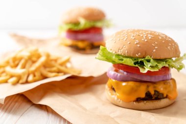 taze lezzetli biftek burger peynir ve patates kızartması ahşap arka plan üzerinde