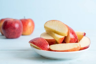 ahşap arka plan üzerinde kase dilimlenmiş taze kırmızı elmalar