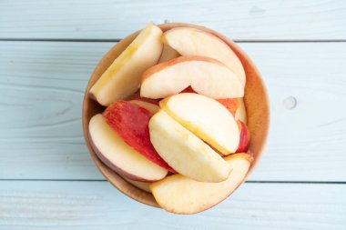 ahşap arka plan üzerinde kase dilimlenmiş taze kırmızı elmalar