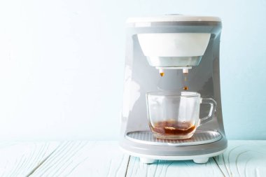 Kahve makinesi ahşap arka planda kahve yapıyor.