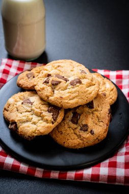 Tabağında çikolata parçaları olan kurabiyeler.