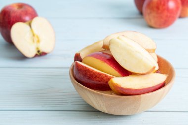 ahşap arka plan üzerinde kase dilimlenmiş taze kırmızı elmalar