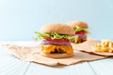 taze lezzetli biftek burger peynir ve patates kızartması ahşap arka plan üzerinde