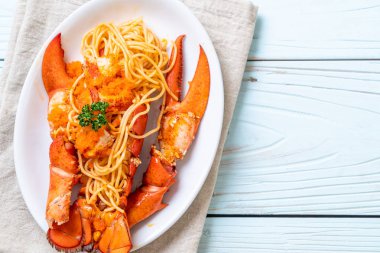 Beyaz tabakta karides yumurtalı ıstakoz spagettisi.