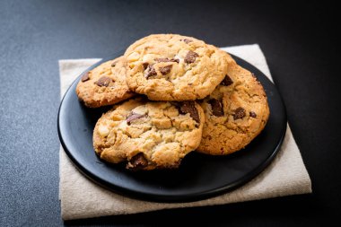 Tabağında çikolata parçaları olan kurabiyeler.