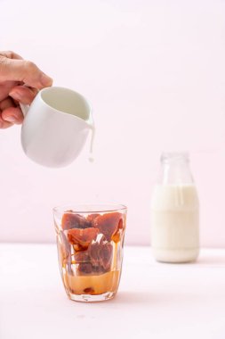 Tay çay buz küpü ile ahşap arka plan üzerinde süt