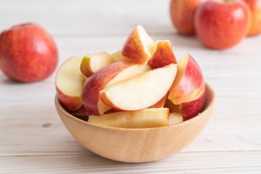 ahşap arka plan üzerinde kase dilimlenmiş taze kırmızı elmalar