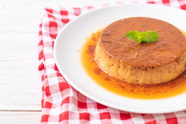 Ev yapımı karamel kremalı puding ahşap arka plan üzerinde