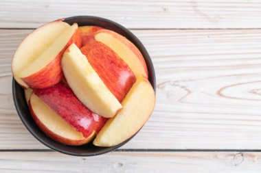 ahşap arka plan üzerinde kase dilimlenmiş taze kırmızı elmalar