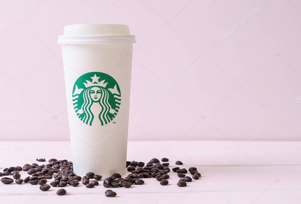 BANGKOK, THAILAND - JUN 5, 2018: White coffee cup with Starbucks logo on wood background. Starbucks is the world's largest coffee house with over 20,000 stores in 61 countries.