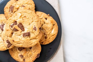 Tabağında çikolata parçaları olan kurabiyeler.