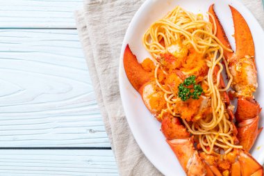 Beyaz tabakta karides yumurtalı ıstakoz spagettisi.