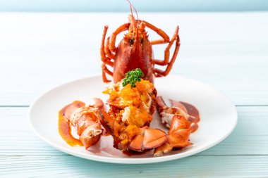 Soslu ıstakoz kuyruklu biftek ve beyaz arka planda karides yumurtaları.