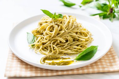 Spagetti pesto sos, zeytin yağı ve fesleğen yaprakları ile.