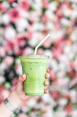 buzlu matcha latte yeşil çay bardağı tutan el 