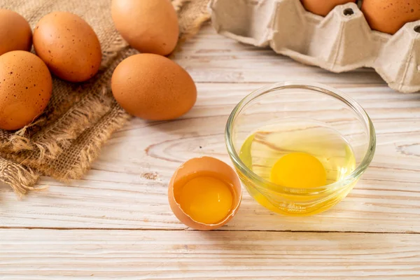 Brown eggs with one broken and egg yolk — Stock Photo, Image