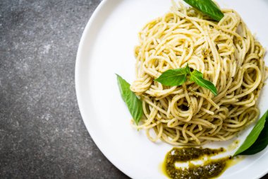 Spagetti pesto sos, zeytin yağı ve fesleğen yaprakları ile.