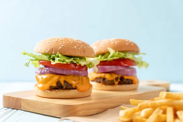 Hambúrguer de carne fresca saborosa com queijo e batatas fritas — Fotografia de Stock