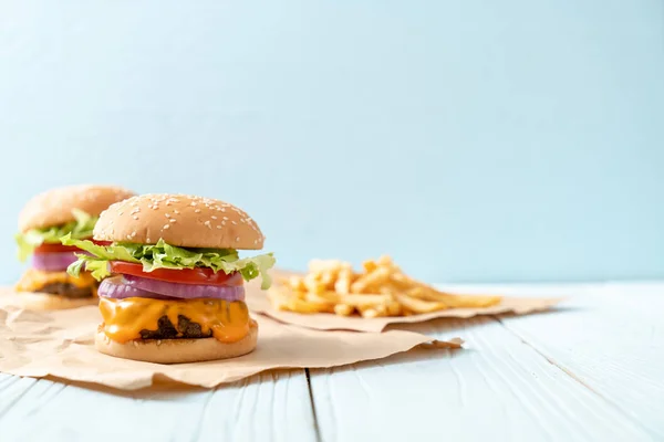 Frische leckere Rindfleisch-Burger mit Käse und Pommes frites — Stockfoto