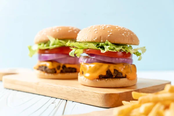 Hambúrguer de carne fresca saborosa com queijo e batatas fritas — Fotografia de Stock