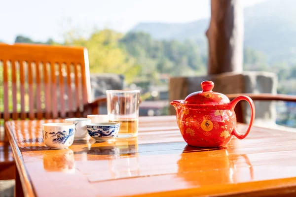 Theepot en kopje op de tafel met ochtendzon — Stockfoto