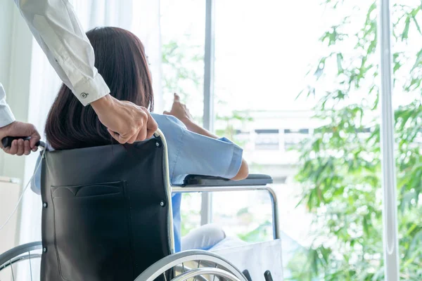 Kvinnlig patient på rullstolen med överläkare — Stockfoto