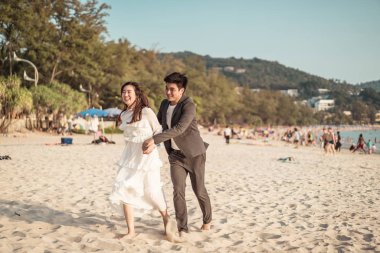 Mutlu çift balayı gidiş tropikal kum plajı üzerinde su içinde seyahat.