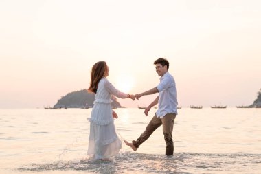 Mutlu çift balayı gidiş tropikal kum plajı üzerinde su içinde seyahat.