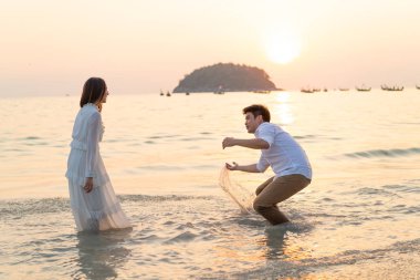 Mutlu çift balayı gidiş tropikal kum plajı üzerinde su içinde seyahat.