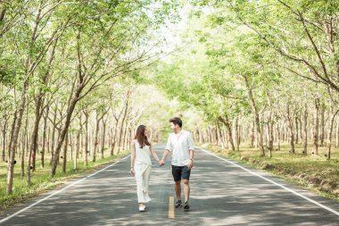 Ağaç arch ile yolda aşık mutlu Asya çift