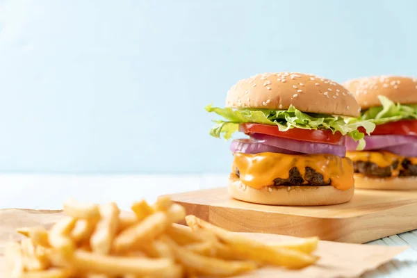 Frische leckere Rindfleisch-Burger mit Käse und Pommes frites — Stockfoto