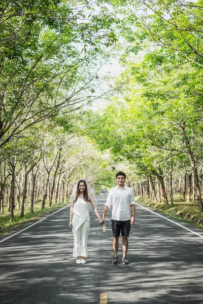 Feliz ásia casal no amor no estrada com árvore arco — Fotografia de Stock