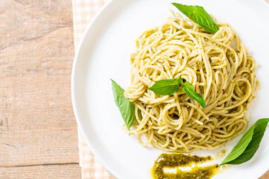 Spagetti pesto sos, zeytin yağı ve fesleğen yaprakları ile.