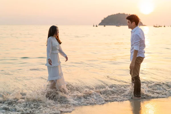 Mutlu çift balayı gidiş tropikal kum plajı üzerinde su içinde seyahat.