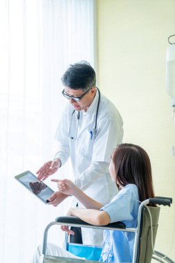 tekerlekli sandalye ile kıdemli doktor kadın hastayı