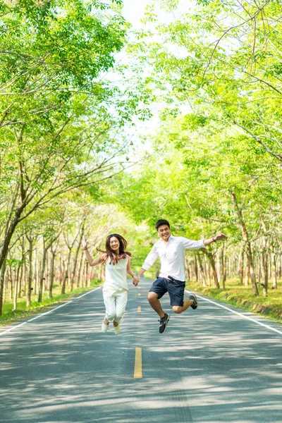 Gelukkige Aziatische paar verliefd op weg met boom boog — Stockfoto