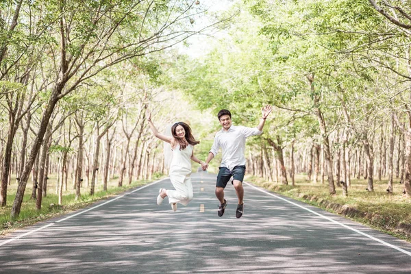 Gelukkige Aziatische paar verliefd op weg met boom boog — Stockfoto