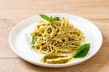 Spagetti pesto sos, zeytin yağı ve fesleğen yaprakları ile.