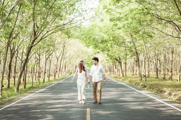 Gelukkige Aziatische paar verliefd op weg met boom boog — Stockfoto