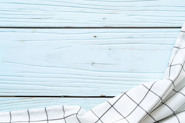 青い木製の背景の上にキッチン布 (ナプキン) — ストック写真