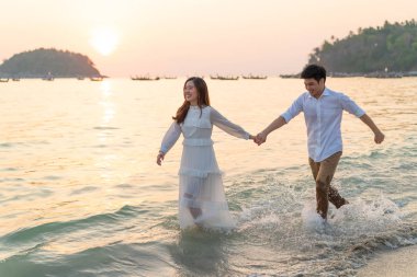 Mutlu çift balayı gidiş tropikal kum plajı üzerinde su içinde seyahat.