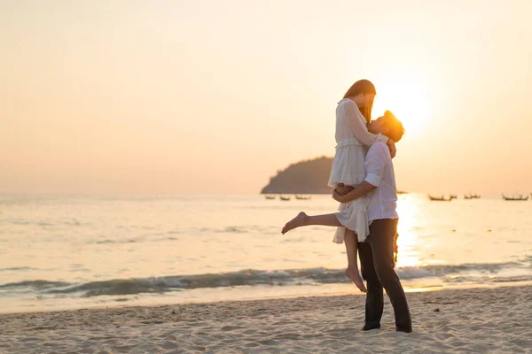 新婚旅行に行く幸せなカップルは su で熱帯の砂浜のビーチに旅行します。 — ストック写真