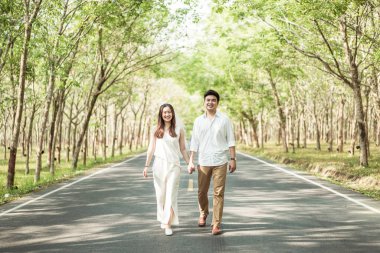 Ağaç arch ile yolda aşık mutlu Asya çift