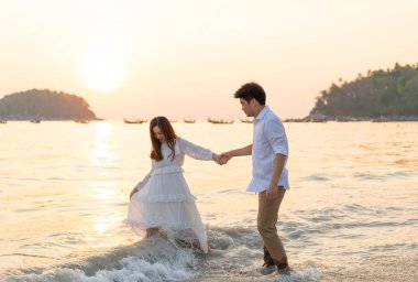 Mutlu çift balayı gidiş tropikal kum plajı üzerinde su içinde seyahat.